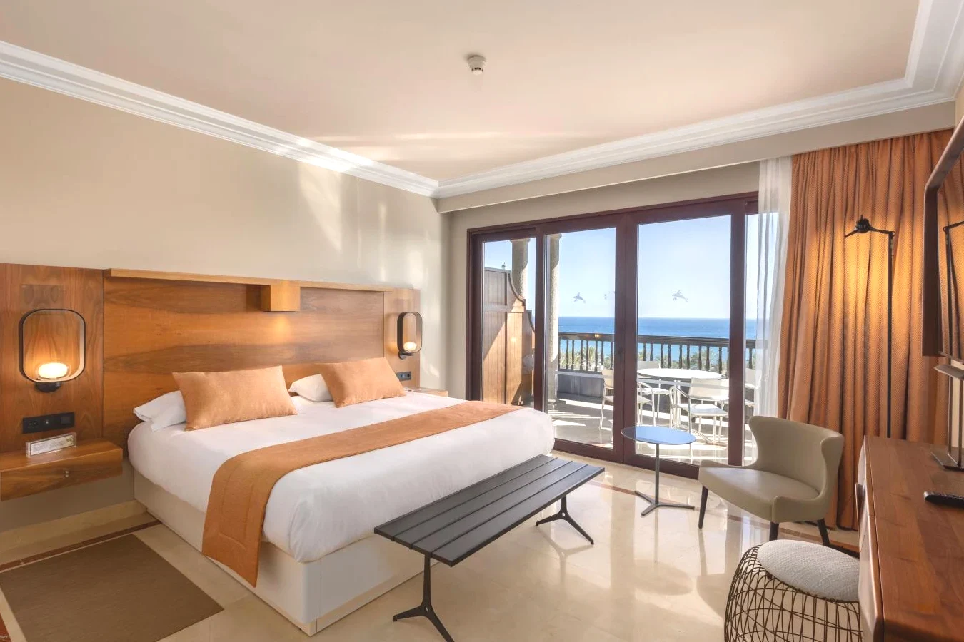 Dormitorio con una cama, un escritorio y un balcón con vistas al mar Unique Club at Lopesan Costa Meloneras Resort, en Maspalomas
