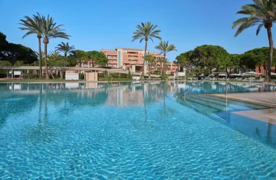 Piscina con palmeras del cinco estrellas Hipotels Hipocampo Palace & Spa en Cala Millor