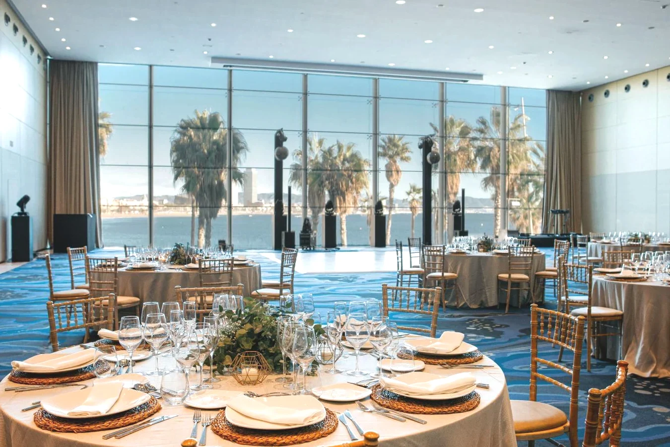 Salón de banquetes con mesas y sillas y una gran ventana con vistas al mar en W Barcelona